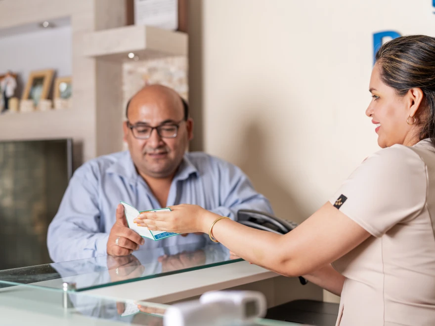 A team member checking out a patient at the front desk