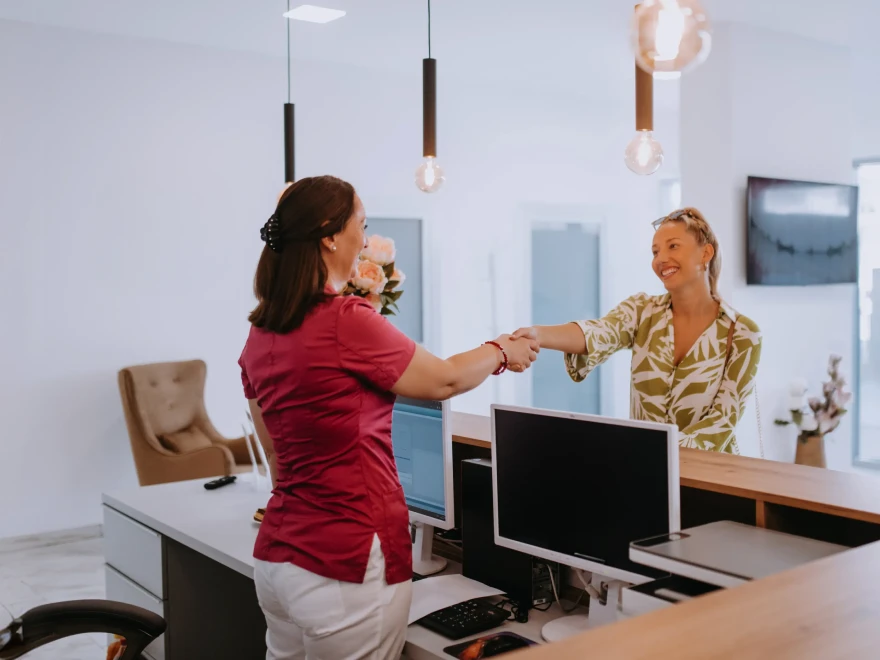 A team member greeting a patient at the front desk