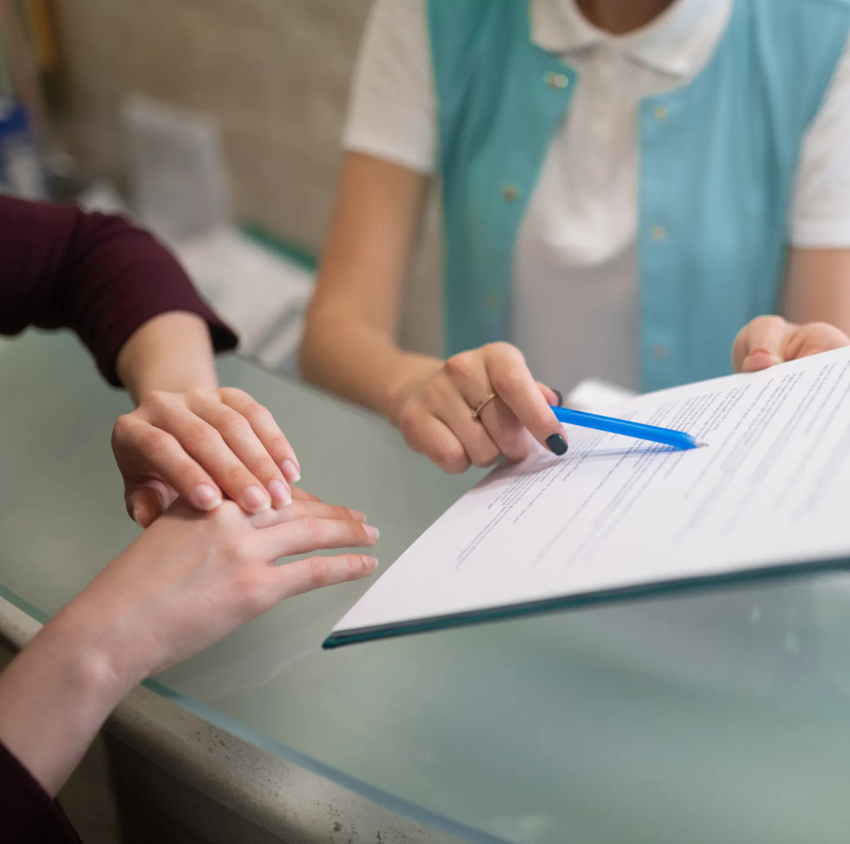 A patient signing a form at the front desk