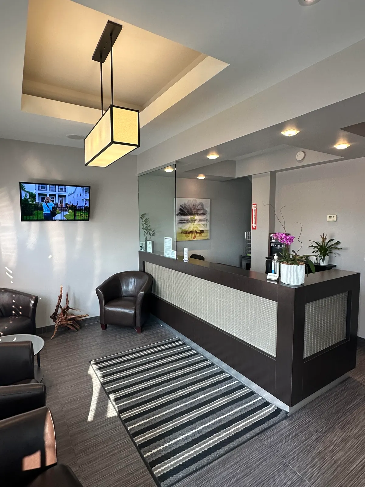 LIV waiting room with leather armchairs, a striped rug and the front reception desk