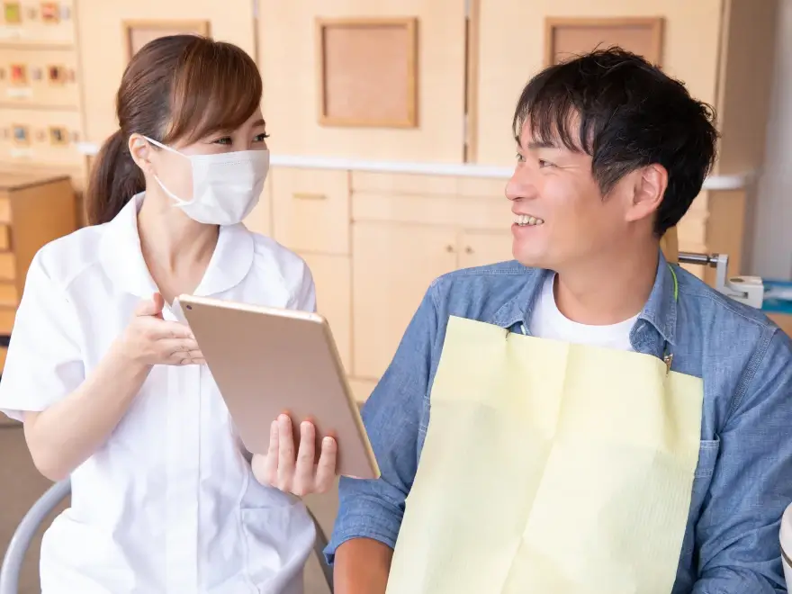 A patient reviewing a tablet with a dental team member
