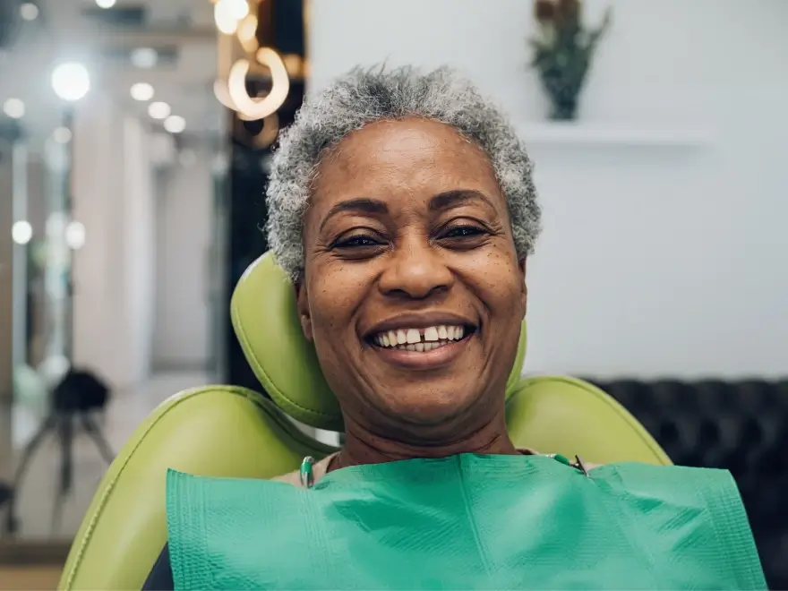 A smiling older woman in the dental chair