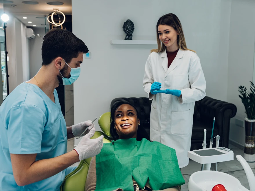 A patient relaxing in the dental chair while two team members prepare