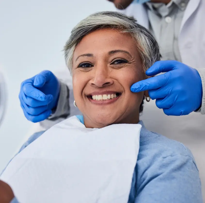 A smiling senior woman having her teeth examined by her dentist