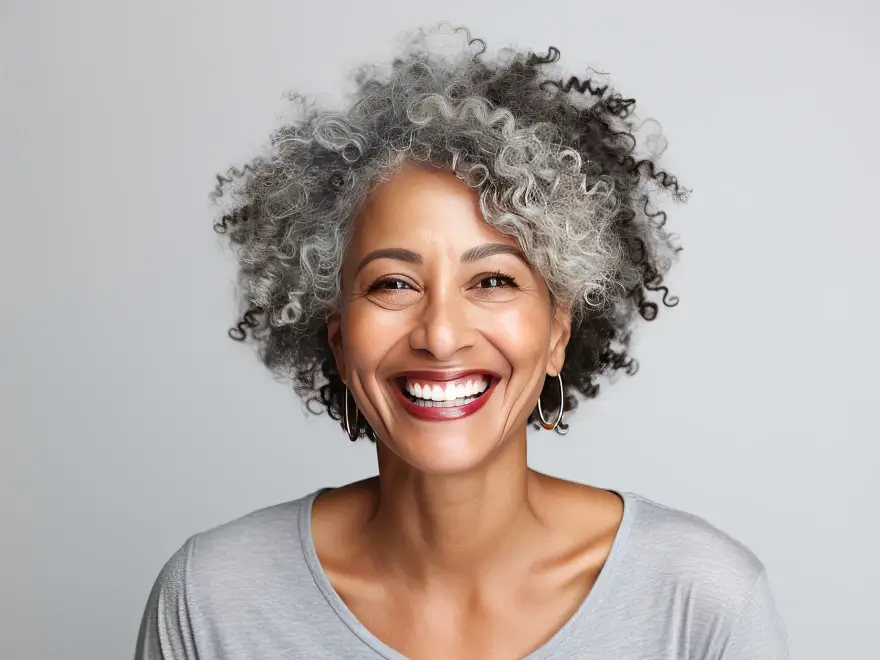 A smiling woman with curly grey hair