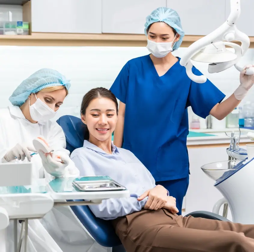 A patient seated in the dental chair with two team members nearby